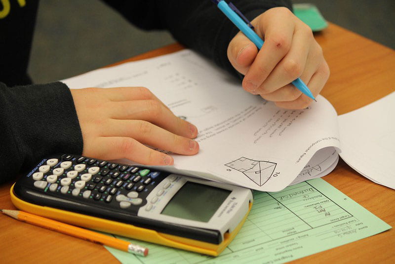Photo of a student's desk with math work and a calculator